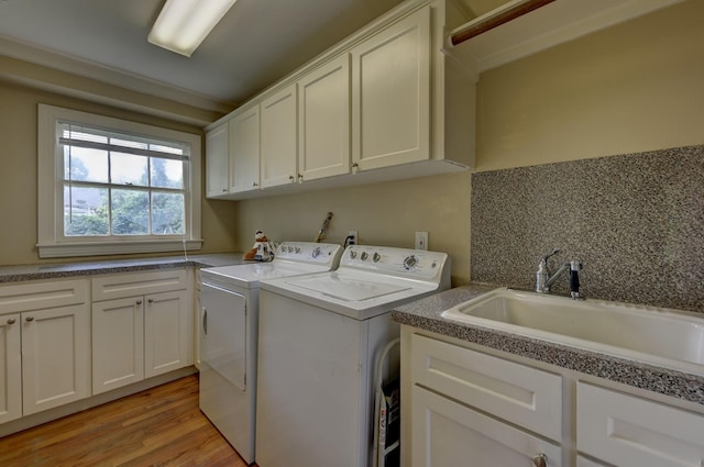 708 4th St, Sealy, TX 77474 - laundry area with washer and clothes dryer, cabinet space, and light wood-type flooring