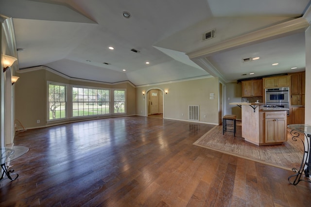 708 4th St, Sealy, TX 77474 - unfurnished living room featuring lofted ceiling, wood finished floors, arched walkways, baseboards, and crown molding