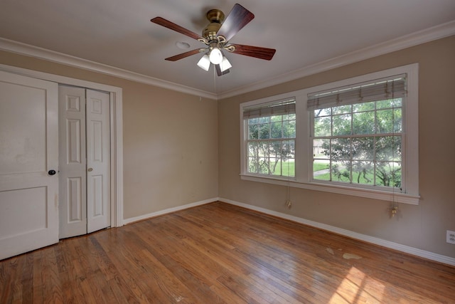 708 4th St, Sealy, TX 77474 - unfurnished bedroom with baseboards, wood finished floors, crown molding, a ceiling fan, and a closet