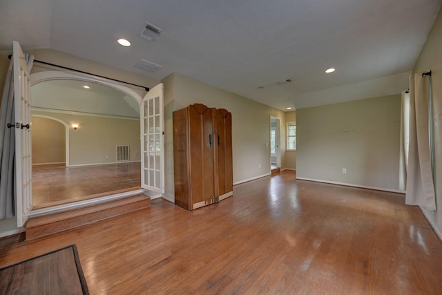 708 4th St, Sealy, TX 77474 - unfurnished room with wood finished floors, arched walkways, recessed lighting, baseboards, and french doors