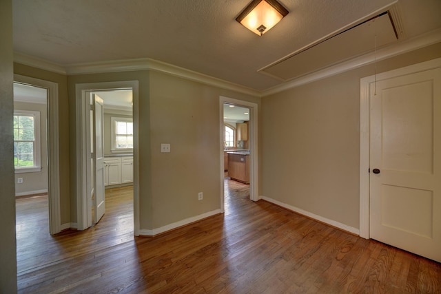 708 4th St, Sealy, TX 77474 - empty room with attic access, wood finished floors, baseboards, and crown molding