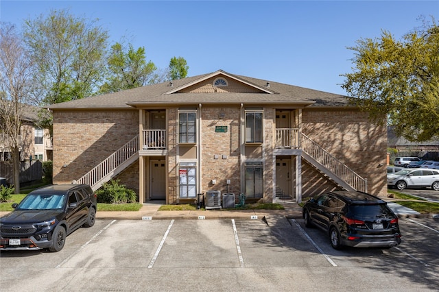 1311 Antoine Dr Unit 245, Houston, TX 77055 - view of building exterior with uncovered parking, central AC, and stairway