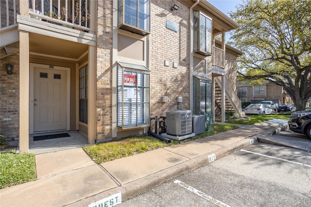 1311 Antoine Dr Unit 245, Houston, TX 77055 - view of exterior entry with brick siding, uncovered parking, and central air condition unit