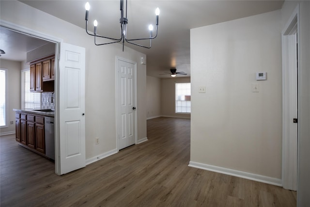 1311 Antoine Dr Unit 245, Houston, TX 77055 - unfurnished dining area featuring a sink, baseboards, ceiling fan with notable chandelier, and dark wood-style flooring
