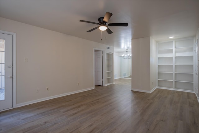 1311 Antoine Dr Unit 245, Houston, TX 77055 - unfurnished room with visible vents, built in features, wood finished floors, baseboards, and ceiling fan with notable chandelier