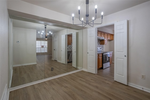 1311 Antoine Dr Unit 245, Houston, TX 77055 - unfurnished dining area featuring baseboards, wood finished floors, and a notable chandelier