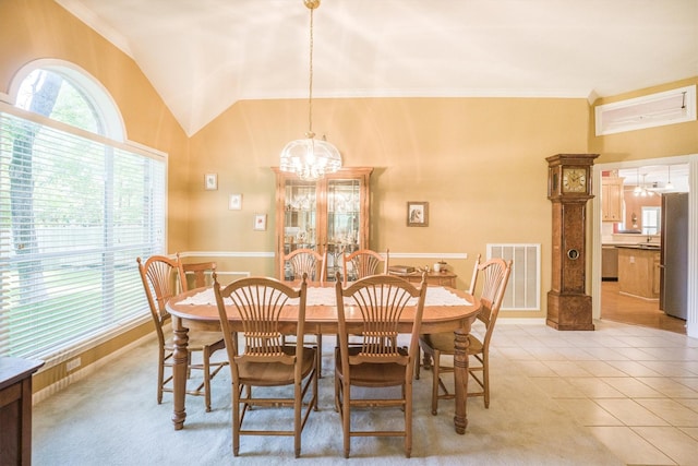 dining room featuring crown molding, visible vents, a chandelier, light tile patterned floors, and vaulted ceiling