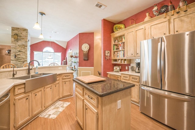 kitchen featuring visible vents, light brown cabinets, a sink, light wood finished floors, and appliances with stainless steel finishes