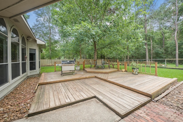deck with a fenced backyard, outdoor dining space, and a yard