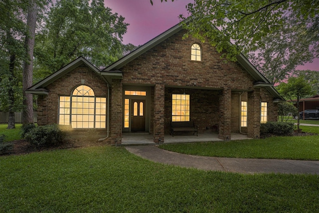 view of front of home featuring brick siding and a front yard