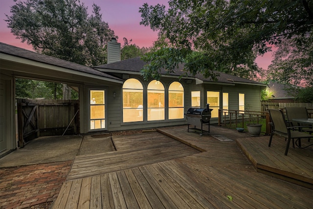 deck at dusk featuring fence