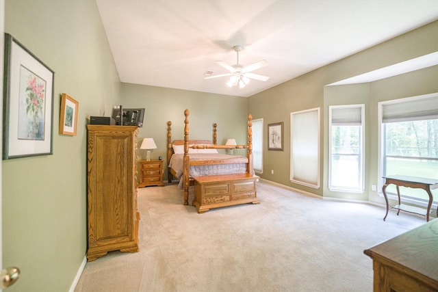 bedroom featuring light colored carpet, a ceiling fan, and baseboards