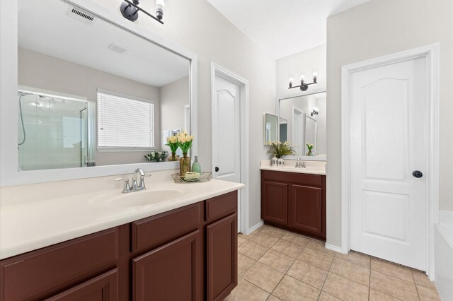 bathroom with a sink, tile patterned floors, two vanities, visible vents, and a stall shower