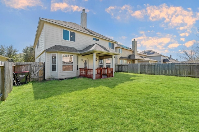 back of property with a shingled roof, a fenced backyard, a chimney, a patio area, and a lawn