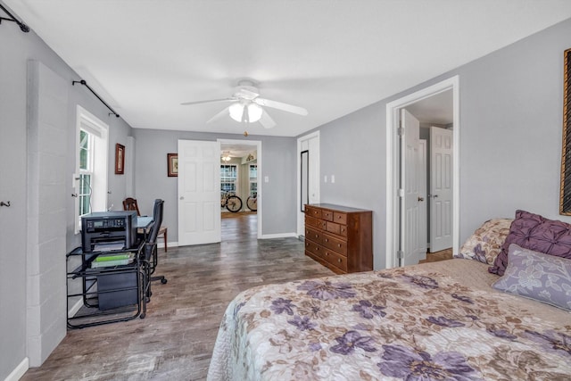 bedroom featuring french doors, a ceiling fan, baseboards, and wood finished floors