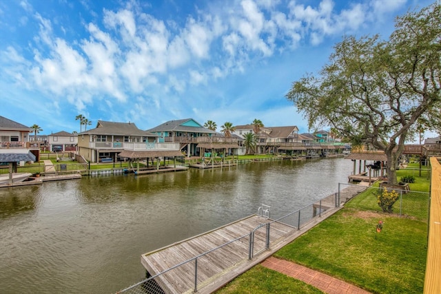 dock area with a residential view, fence, a water view, and a lawn