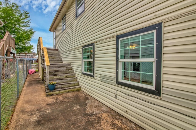 view of home's exterior with stairway and fence
