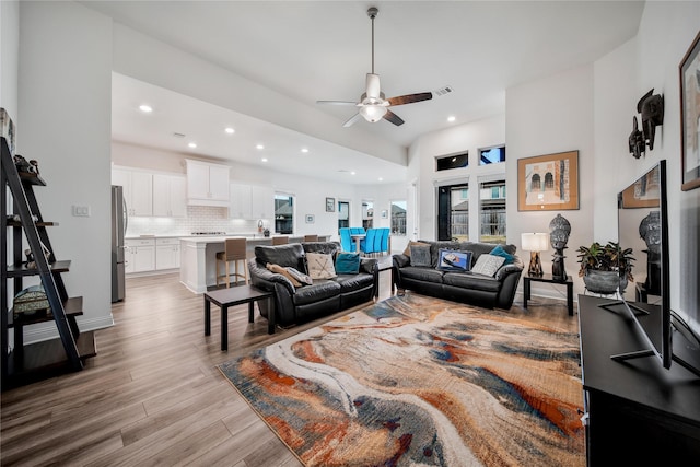 living room featuring recessed lighting, ceiling fan, vaulted ceiling, and light wood-type flooring