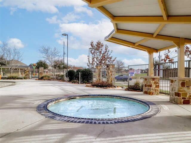 view of swimming pool featuring fence and a gate