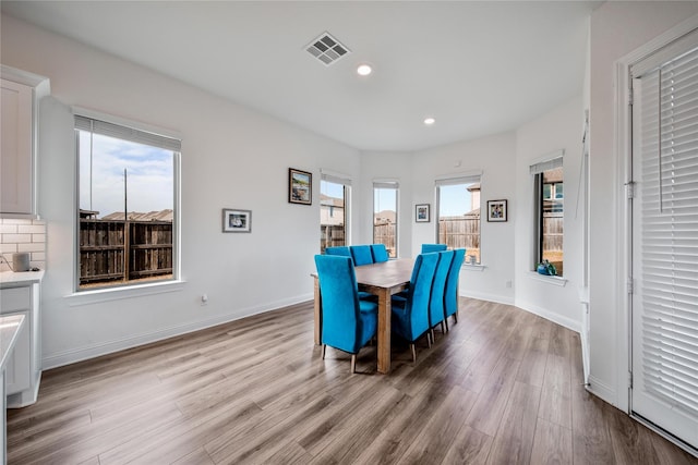 dining space with recessed lighting, baseboards, light wood finished floors, and visible vents