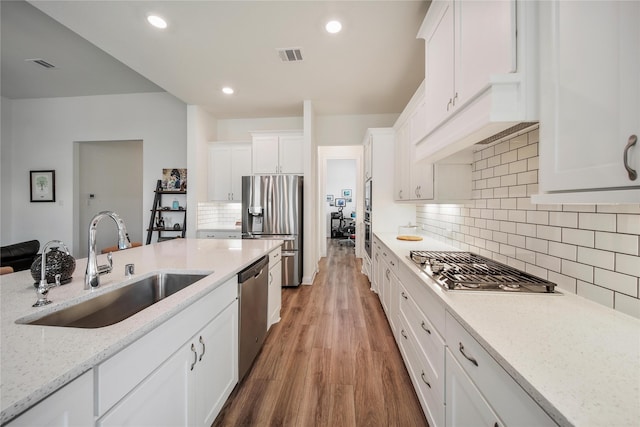 kitchen with visible vents, a sink, white cabinetry, and stainless steel appliances