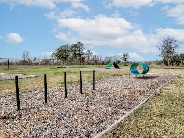 view of home's community with fence and a yard