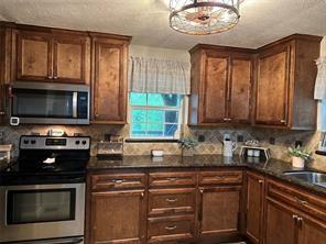 kitchen with stainless steel appliances, a chandelier, a sink, and tasteful backsplash