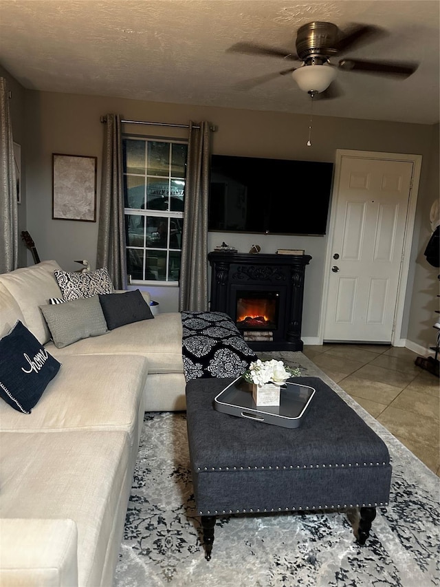 living room with ceiling fan and a glass covered fireplace