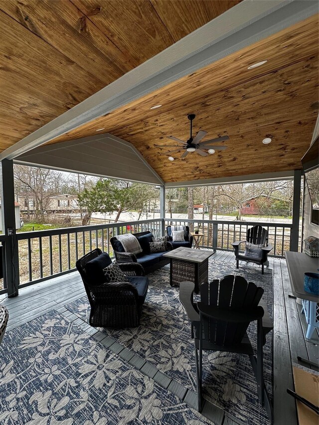 wooden deck featuring outdoor lounge area and a ceiling fan