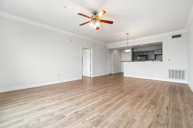 unfurnished living room with visible vents, crown molding, and ceiling fan