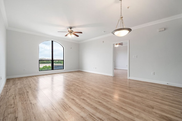 empty room with baseboards, ceiling fan, ornamental molding, and light wood-type flooring
