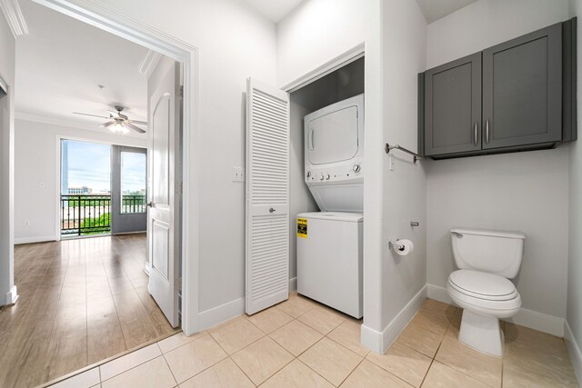 bathroom featuring baseboards, ceiling fan, and stacked washer and dryer