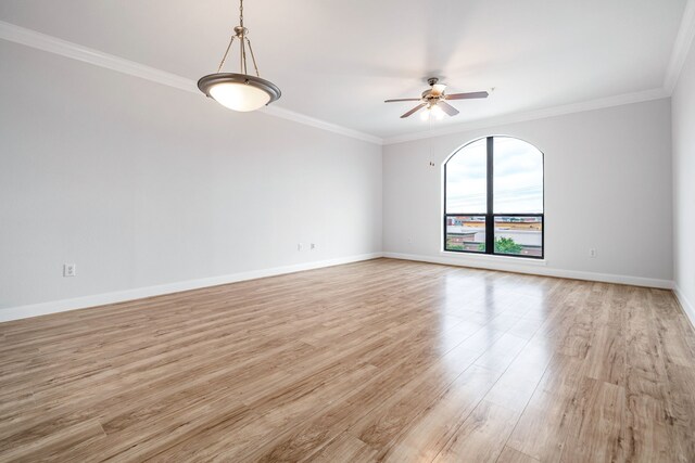 spare room with crown molding, a ceiling fan, baseboards, and light wood-type flooring
