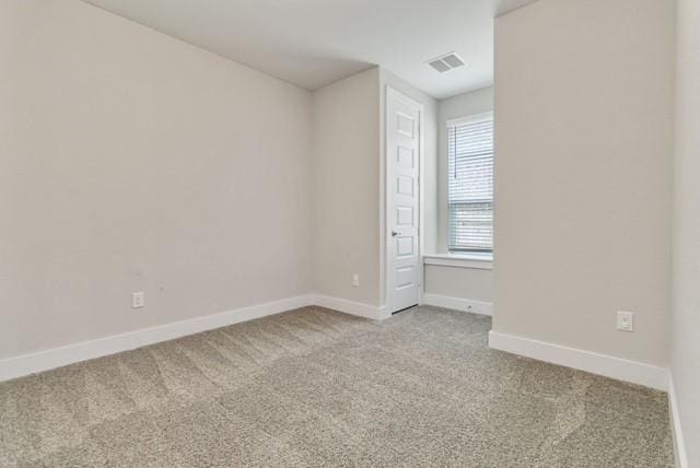 unfurnished room with visible vents, baseboards, and light carpet
