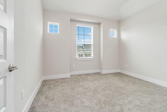 carpeted empty room featuring baseboards