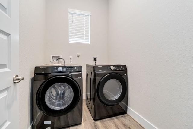 washroom featuring laundry area, light wood-style floors, baseboards, and washer and dryer