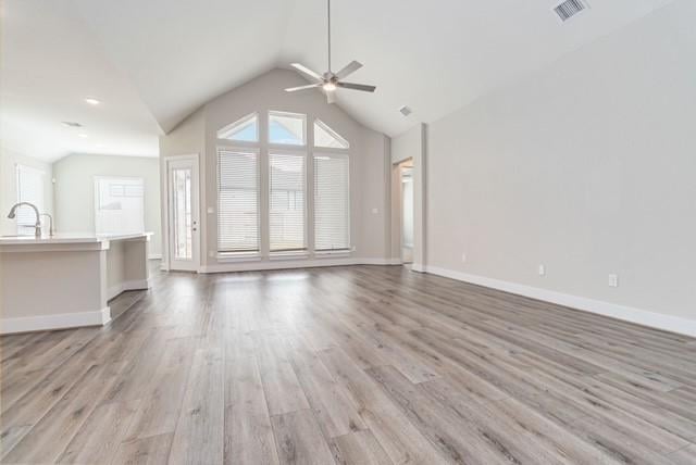 unfurnished living room featuring visible vents, light wood-style floors, ceiling fan, and lofted ceiling
