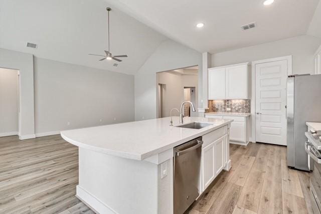 kitchen with visible vents, lofted ceiling, light wood-style floors, a sink, and stainless steel appliances
