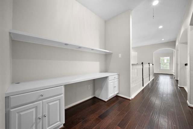 3615 Caleb Ln, Missouri City, TX 77459 - unfurnished office featuring dark wood-style flooring, built in desk, baseboards, arched walkways, and recessed lighting