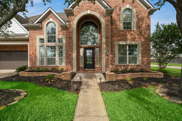 3615 Caleb Ln, Missouri City, TX 77459 - property entrance with brick siding, driveway, an attached garage, and a lawn