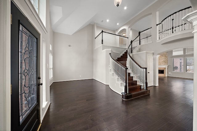 3615 Caleb Ln, Missouri City, TX 77459 - foyer entrance with a towering ceiling, stairs, arched walkways, a fireplace, and decorative columns