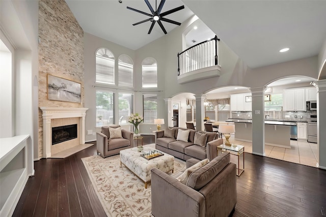 3615 Caleb Ln, Missouri City, TX 77459 - living area with decorative columns, ceiling fan, a high ceiling, a tile fireplace, and hardwood / wood-style floors