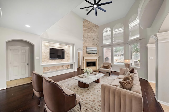 3615 Caleb Ln, Missouri City, TX 77459 - living area featuring a high ceiling, a tile fireplace, a ceiling fan, hardwood / wood-style flooring, and baseboards
