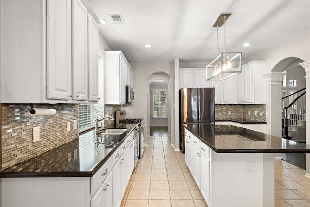 3615 Caleb Ln, Missouri City, TX 77459 - kitchen with arched walkways, stainless steel appliances, dark countertops, and recessed lighting