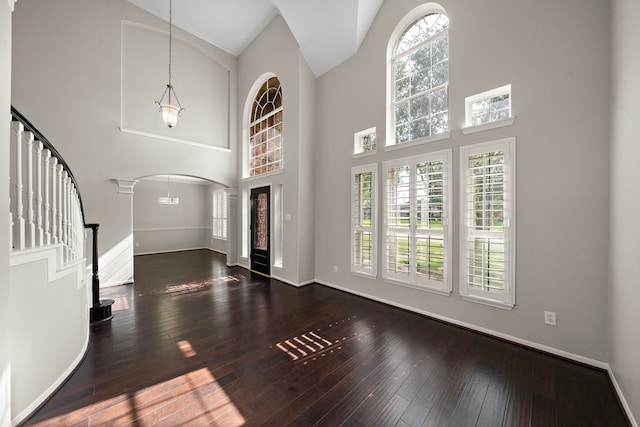 3615 Caleb Ln, Missouri City, TX 77459 - entryway with arched walkways, a towering ceiling, hardwood / wood-style floors, stairway, and baseboards