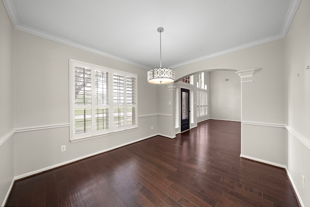 3615 Caleb Ln, Missouri City, TX 77459 - unfurnished dining area featuring ornate columns, arched walkways, baseboards, wood-type flooring, and crown molding