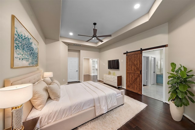 3615 Caleb Ln, Missouri City, TX 77459 - bedroom featuring a barn door, dark wood-type flooring, baseboards, a raised ceiling, and recessed lighting