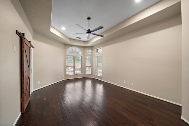 3615 Caleb Ln, Missouri City, TX 77459 - spare room with a barn door, a ceiling fan, a tray ceiling, dark wood-type flooring, and recessed lighting
