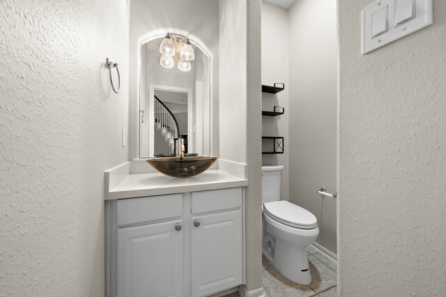 3615 Caleb Ln, Missouri City, TX 77459 - bathroom with vanity, toilet, a chandelier, a textured wall, and tile patterned flooring