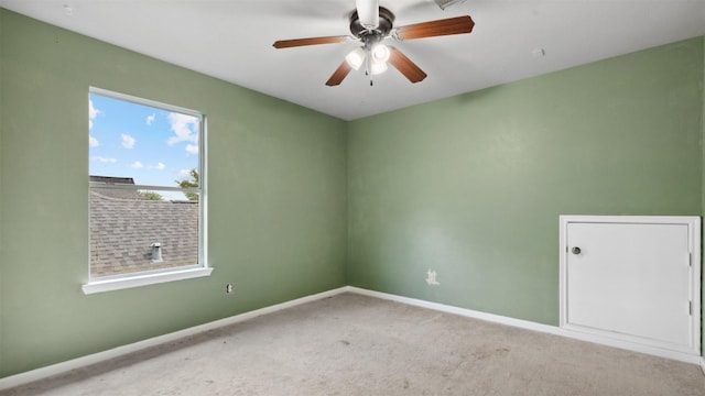 spare room with carpet floors, baseboards, and a ceiling fan